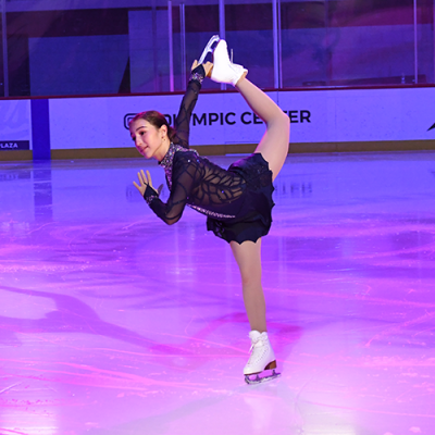 A Figure Skater poses as she performs in the Jack Shea Arena at the Olympic Center under the lights.
